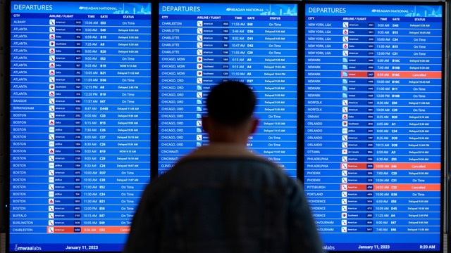 Una persona guarda i tabelloni con i voli in un aeroporto