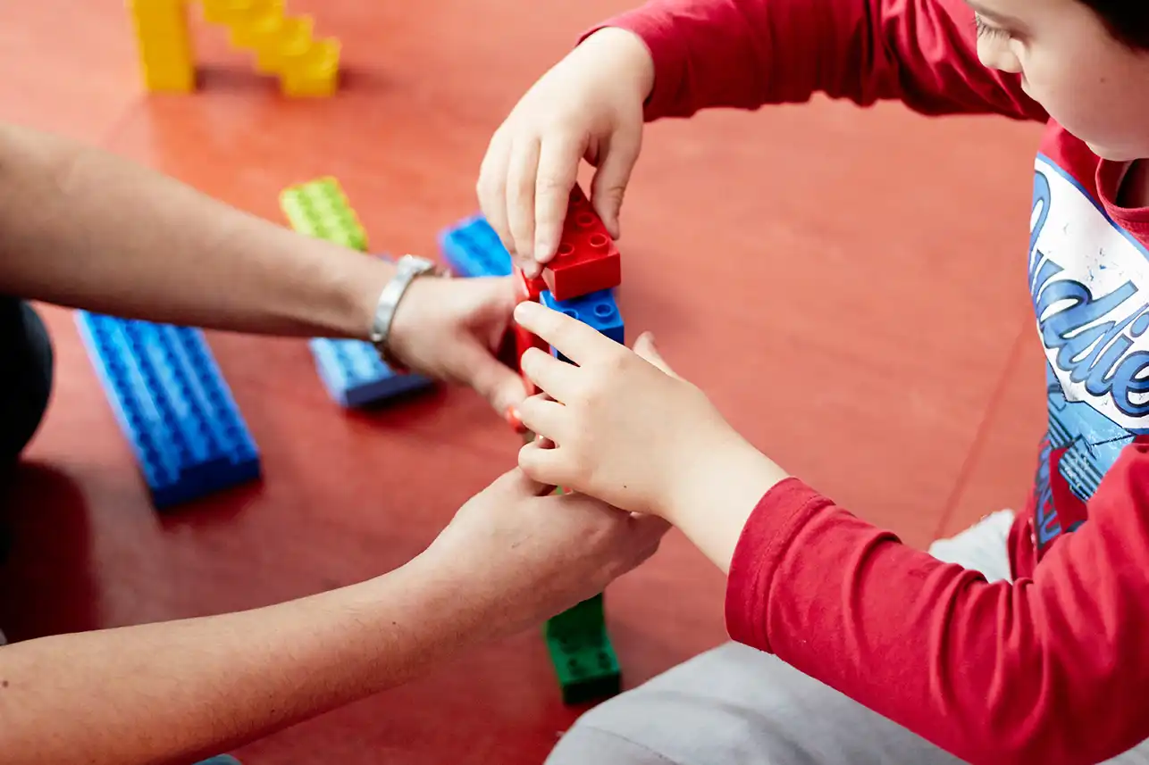Un bambino con disabilità gioca con i Lego