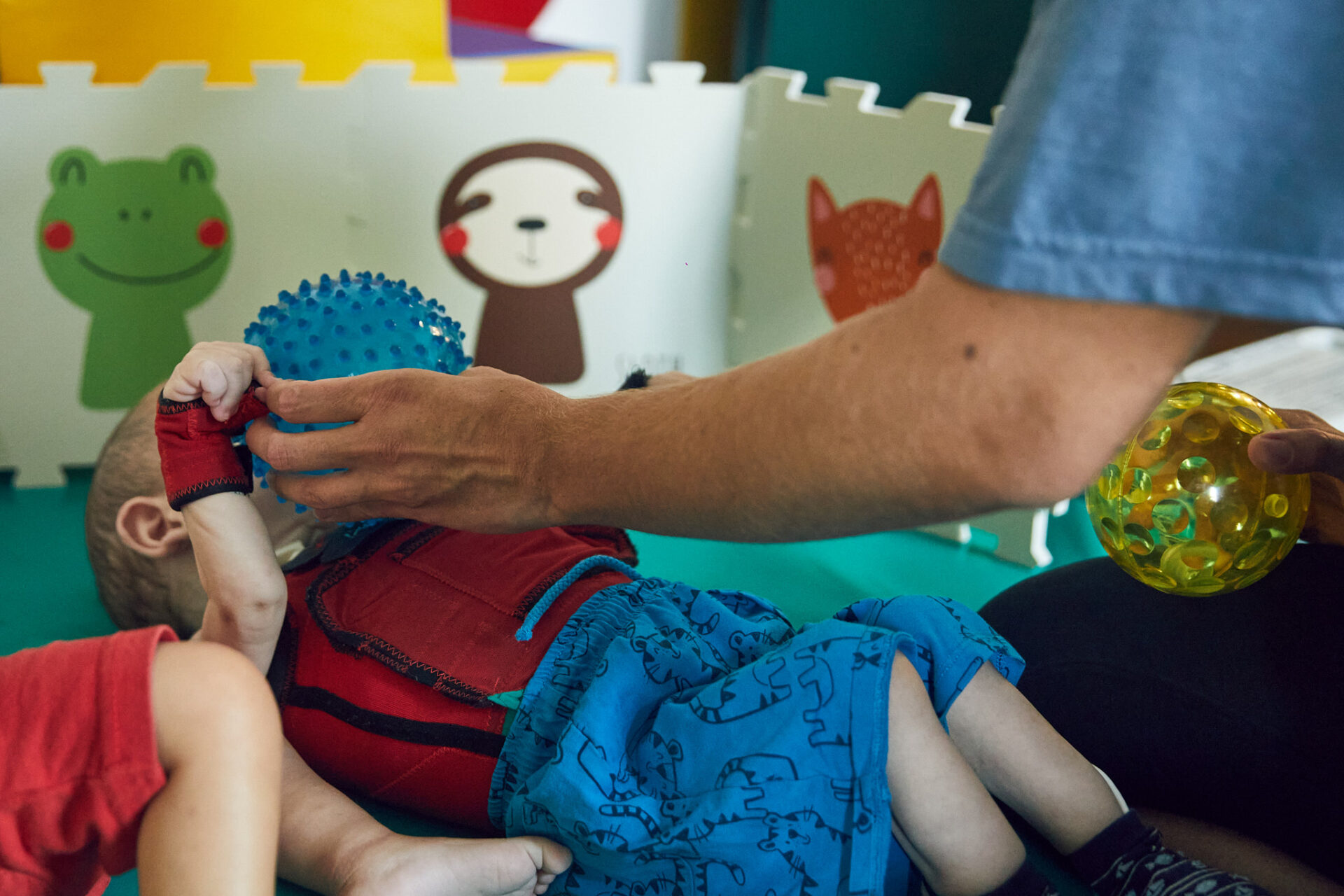 In questa foto si vede un bambino di La Casa che interagisce con una palla grazie alla mediazione di un operatore