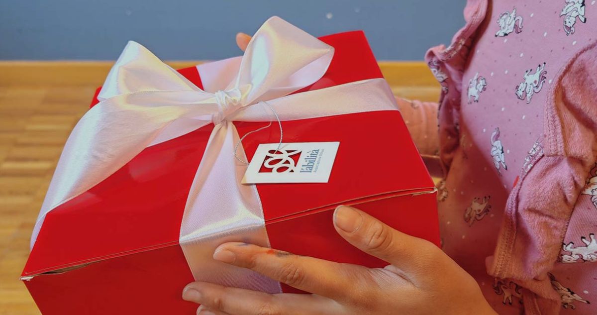 In questa foto si vede una bambina che tiene in mano un regalo