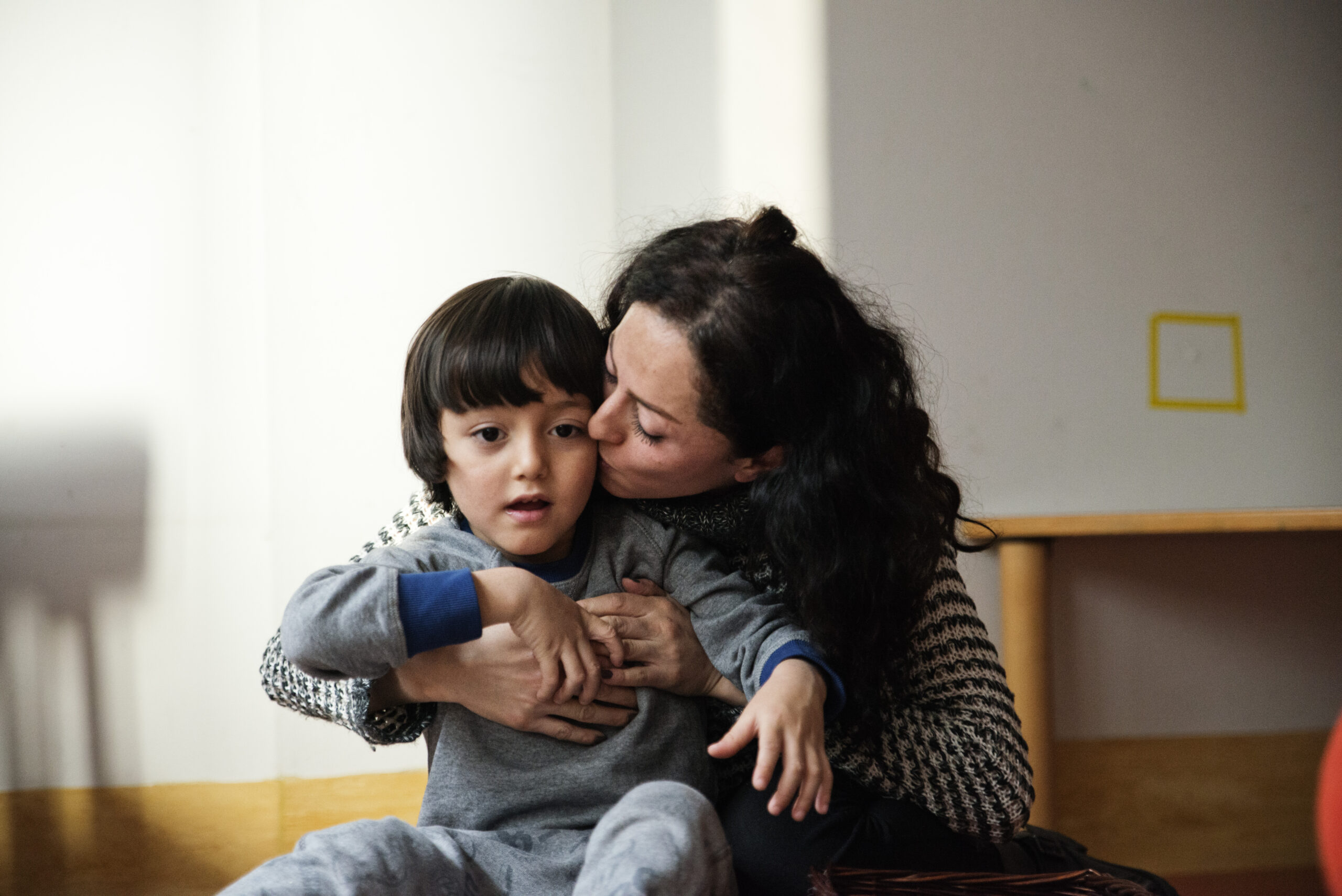 In questa foto si vede una mamma che bacia suo figlio